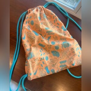 Nike Orange Drawstring Bag with Teal Graphic Print